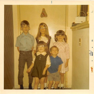 five kids in front of a door.